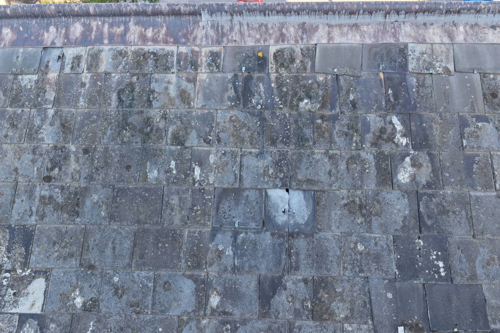 Close aerial view of the weathered slate roof covering of The White House, showing lichen growth and replacement slates